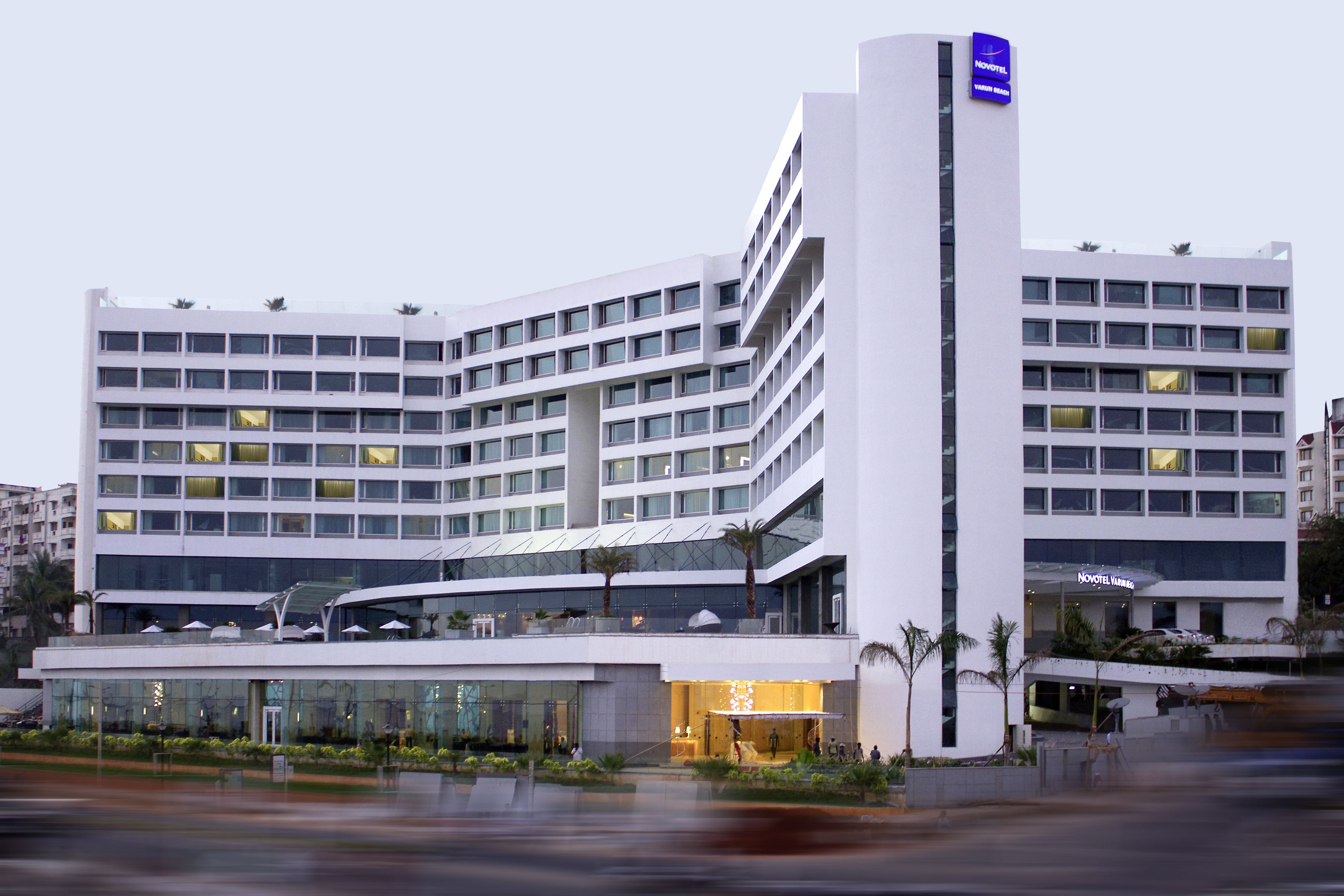 Un hotel moderno con varios pisos, amplias ventanas y una entrada destacada con zona cubierta.