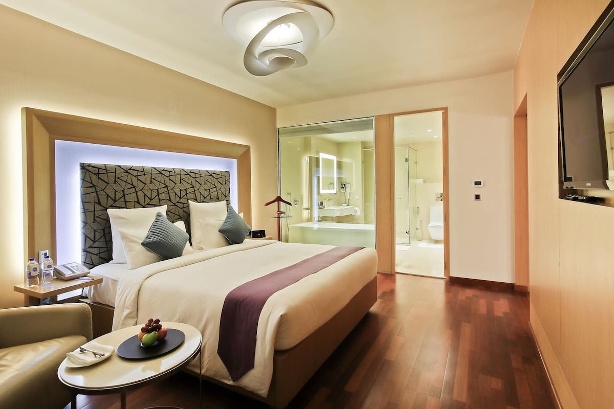Ein Hotelzimmer mit Bett, Nachttisch und Fernseher.
