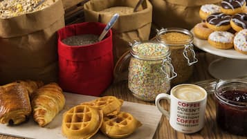 Variedad de productos horneados, como cruasanes y gofres, junto con café y frascos de especias.