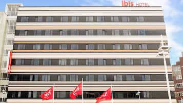 Hotel ibis features a modern architectural design with a flat roof and horizontal windows.