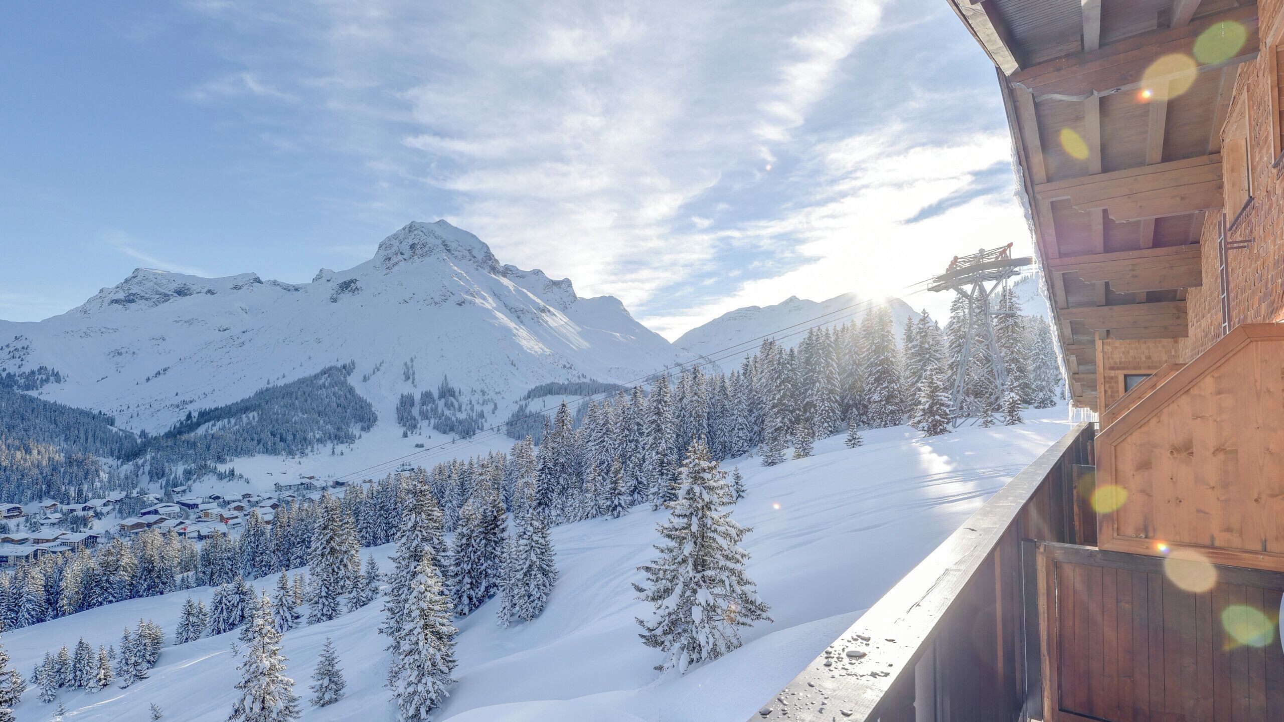 Une vue sur la montagne, avec un chalet en bois et un télésiège.