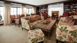 Una sala de estar acogedora con un sofá floral, una mesa de centro de madera y una chimenea.