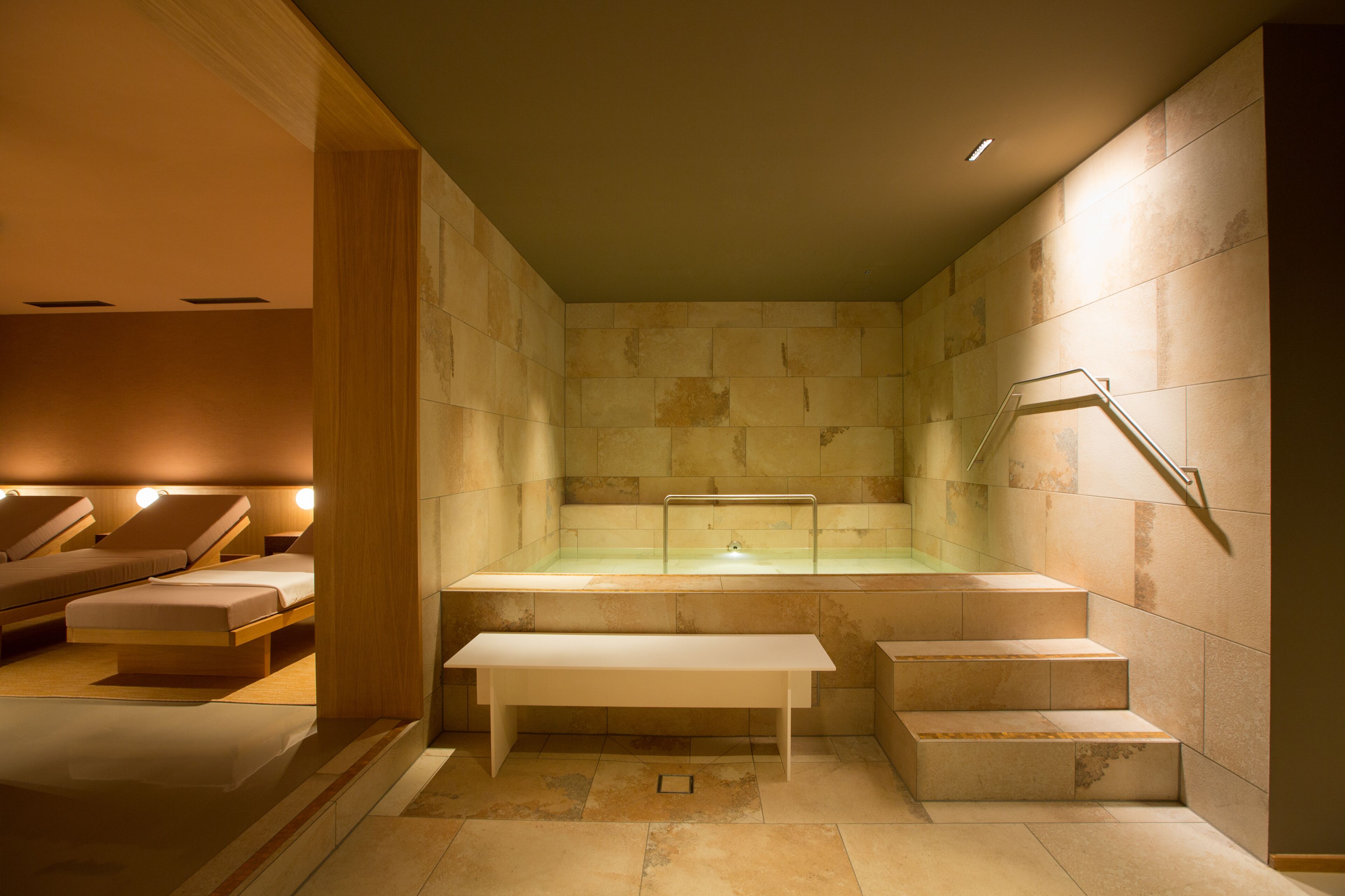 Une salle de spa équipée d’une baignoire, d’un coin salon et d’un escalier.