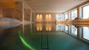 Una piscina interior espaciosa con amplias ventanas que ofrecen vistas al exterior.