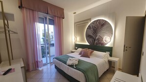 A hotel room with a bed, a nightstand, a wardrobe, and a view of the outside. - Hotel Angelini (Rimini)