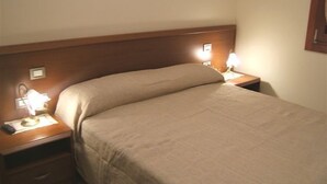 A hotel room with a single bed, a nightstand, a lamp, and a wall-mounted light. - Locanda Canareggio (San Biagio di Callalta)