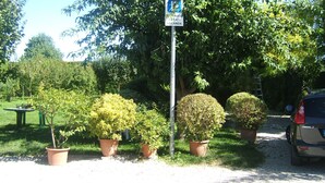 A garden with potted plants and a sign. - Locanda Canareggio (San Biagio di Callalta)
