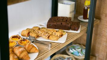 En frukostbuffé med bakverk, bröd och tillbehör.