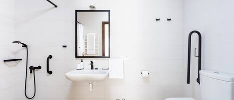 Ein modernes Badezimmer mit Waschbecken, Spiegel und Toilette in Weiß.
