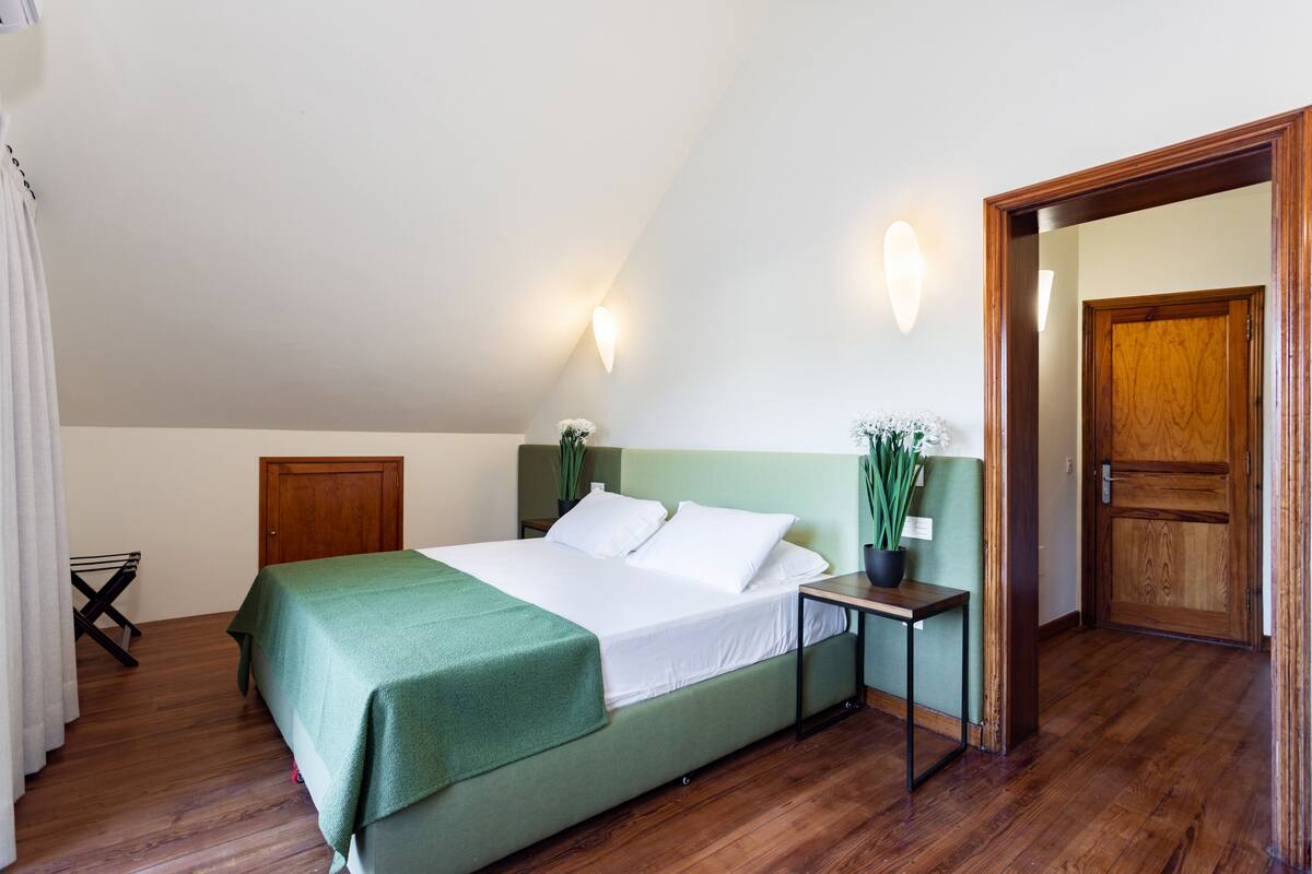 A bedroom with a bed, bedside table, and a door.