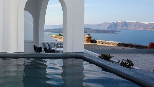 Zona de piscina con vista al mar y a las montañas.
