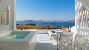 Una piscina infinita blanca con vistas al mar y a las montañas.