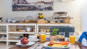 A breakfast table with plates of food, drinks, and a fruit. - Harmony Hotel Nafplio (Nafplio)