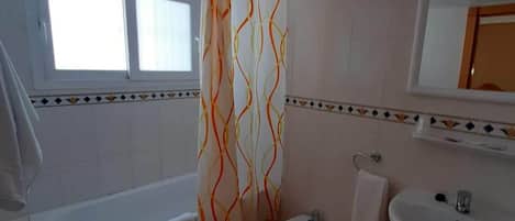 Un baño con inodoro, bidé, bañera y lavamanos.