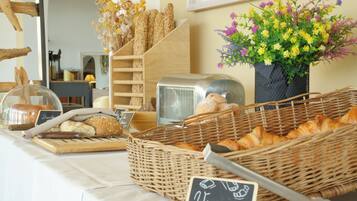 A bakery display with various breads and pastries, a toaster, and a sign in French.