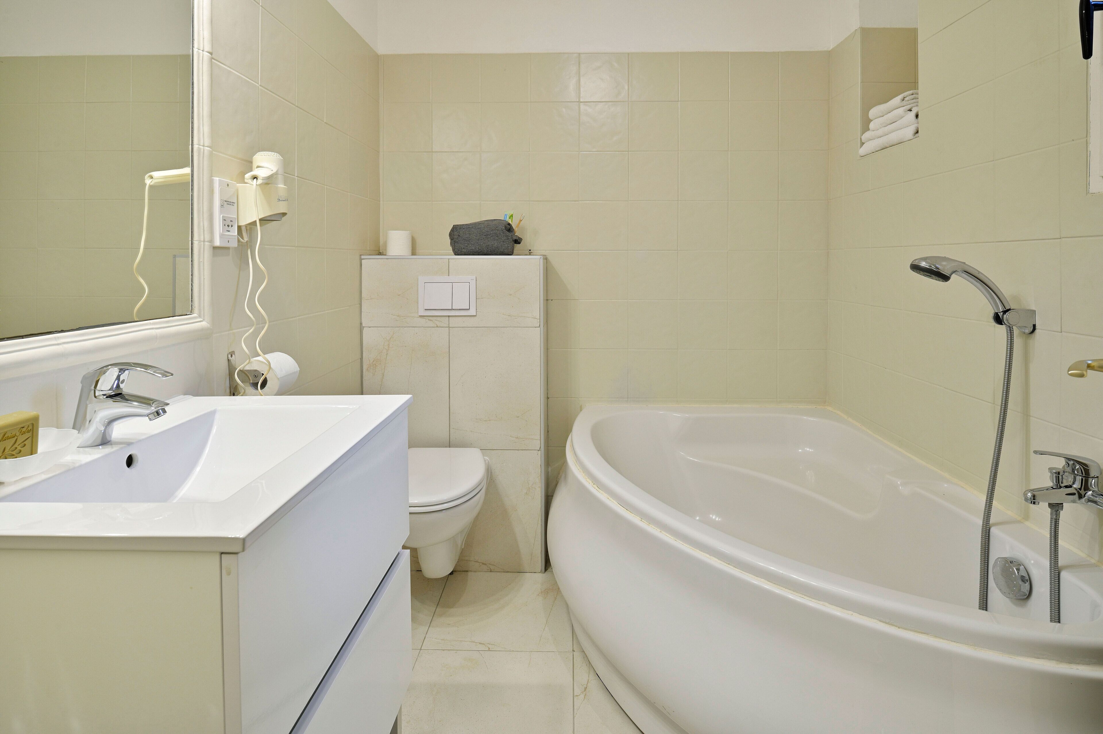 Ein Badezimmer mit Waschbecken, Toilette und Badewanne.