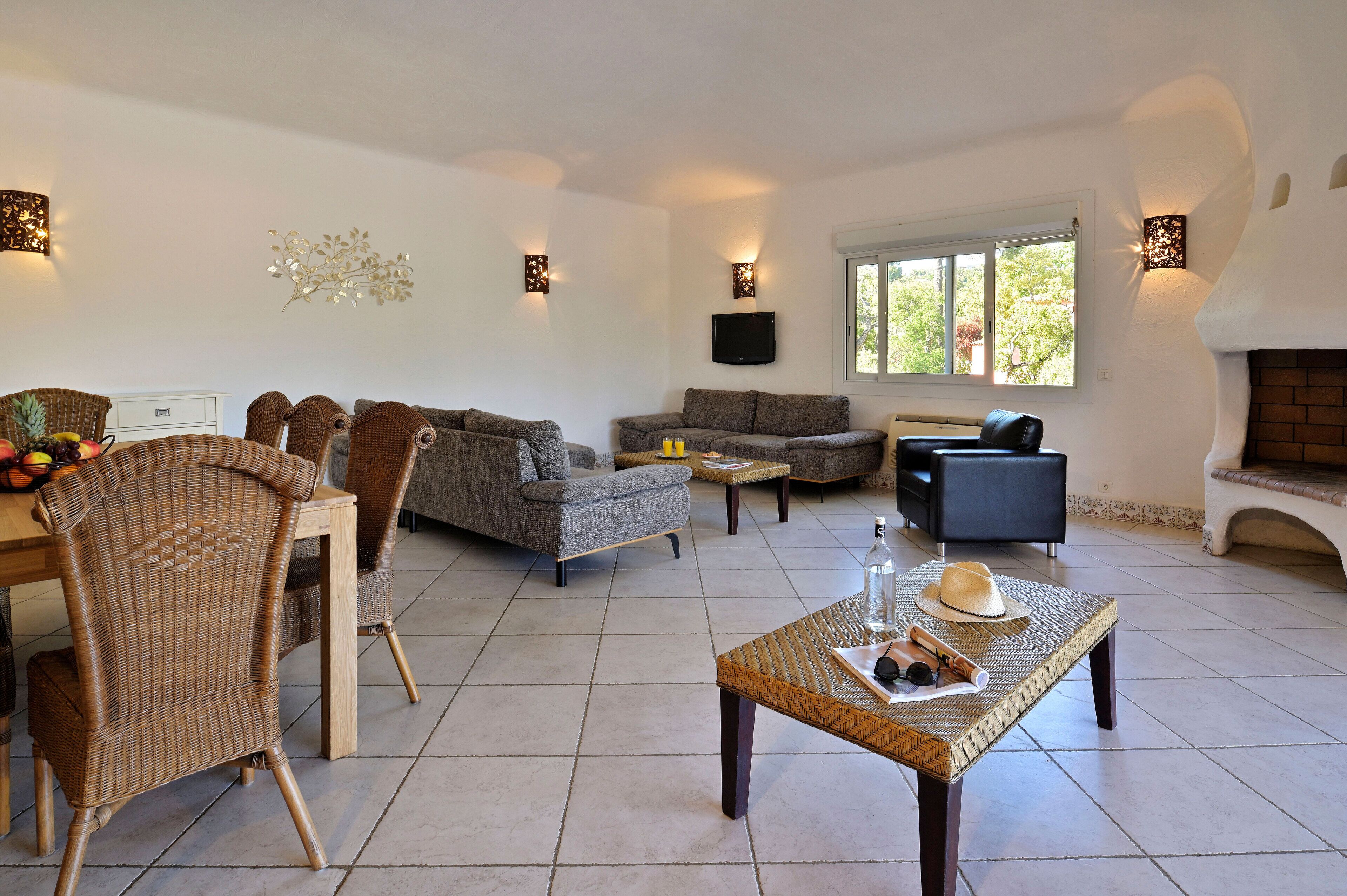 Un vaste espace de vie comprenant un canapé, des fauteuils, une table basse et une cheminée.