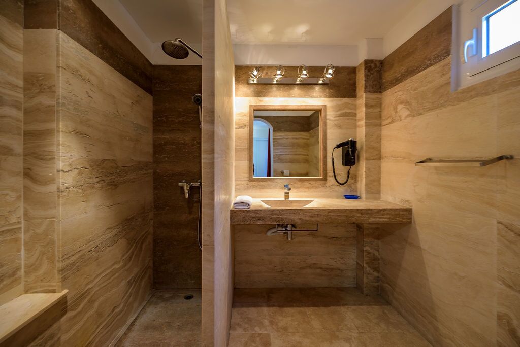 Une salle de bain moderne avec une douche à l’italienne, un meuble-lavabo avec un miroir et un porte-serviettes.