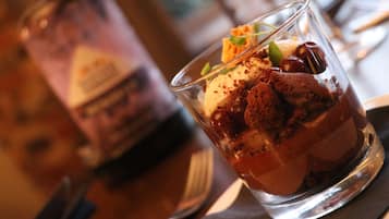 Ein Dessert im Glas, mit Gabel und Serviette daneben.