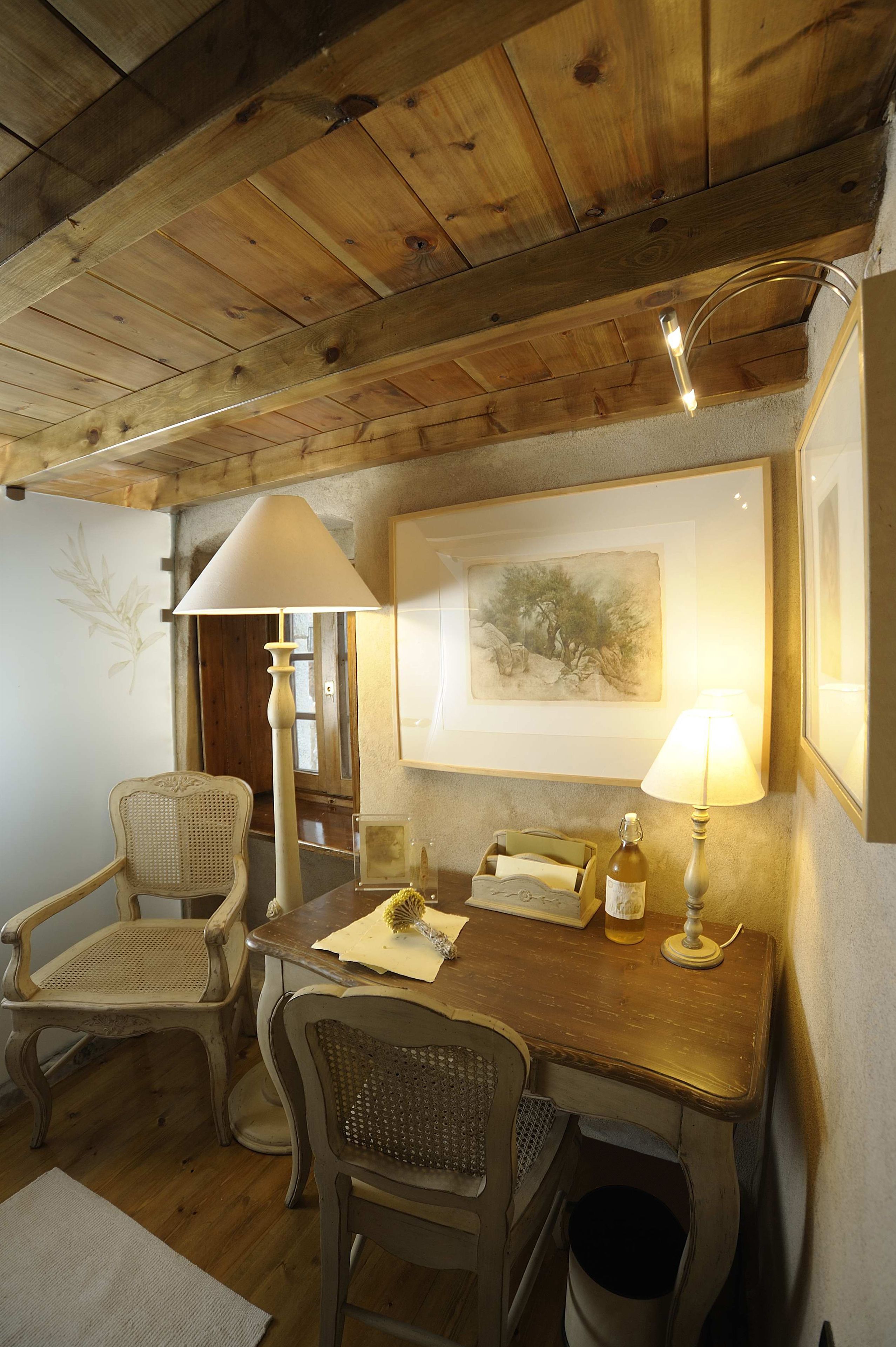 A wooden dining area with a table, chairs, and a lamp.