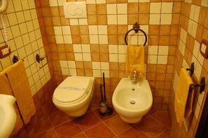 A small bathroom with a toilet, bidet, and a towel rack. - Palazzo Mascambruno (Cariati)