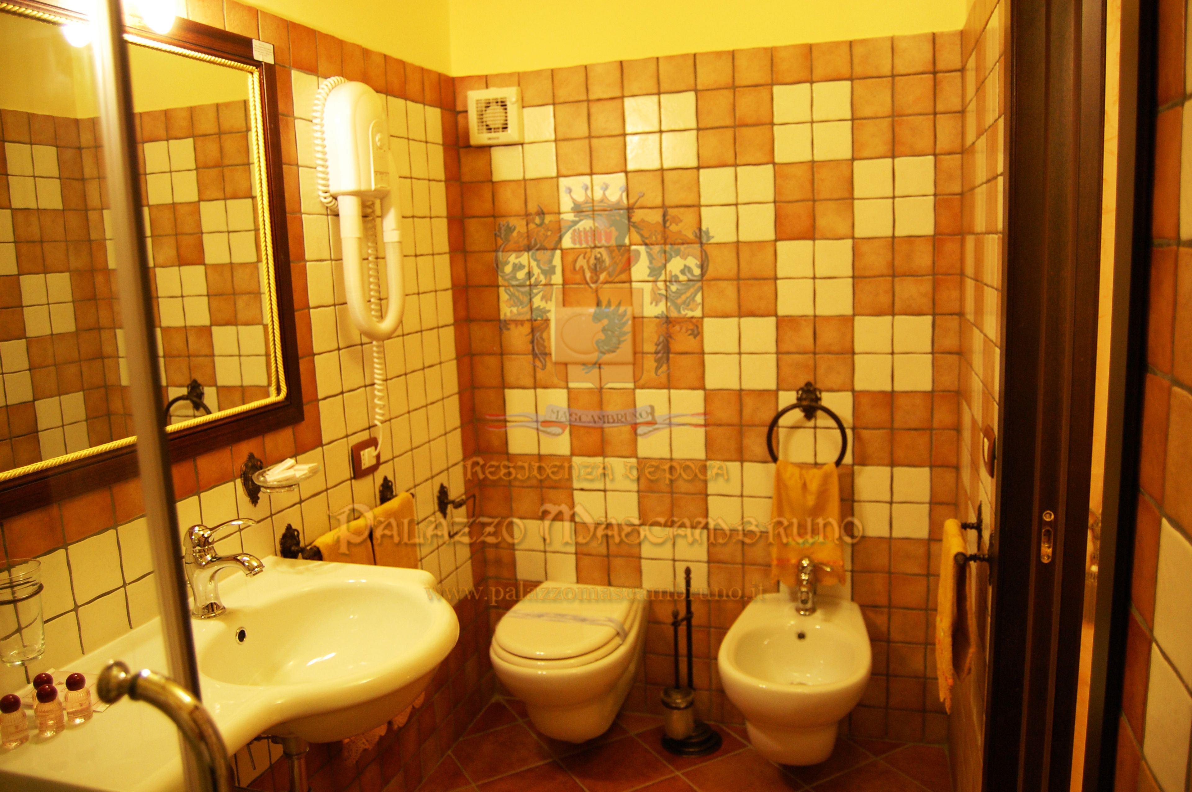 Une salle de bain avec deux lavabos, des toilettes et un bidet.