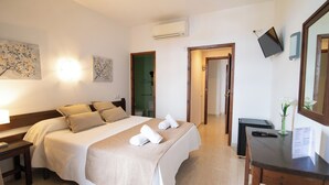 A hotel room with a bed, bedside tables, a desk, a mirror, and artwork on the walls. - Hotel Galera (Sant Antoni de Portmany)