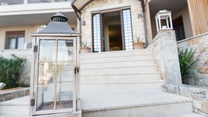 A stone staircase leading to a building entrance with a lantern on the left. - Stamos Hotel (Kassandra)