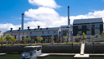 A modern building with a sign reading "turbine" and a boat docked at a marina.