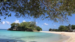 A beach with clear turquoise water, a rocky outcrop, and a sandy shore. - Argonauta Boracay Boutique Hotel with Apartments and Villas (Boracay Island)