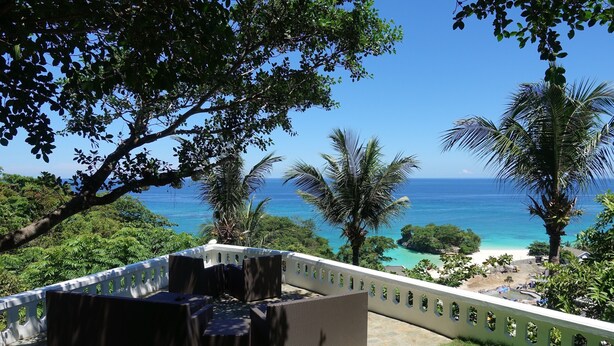 A patio with outdoor furniture overlooking a beach and ocean. - Argonauta Boracay Boutique Hotel with Apartments and Villas (Boracay Island)