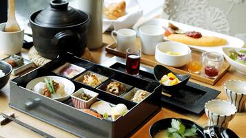 A traditional Japanese meal setup with various dishes and utensils on a wooden table.
