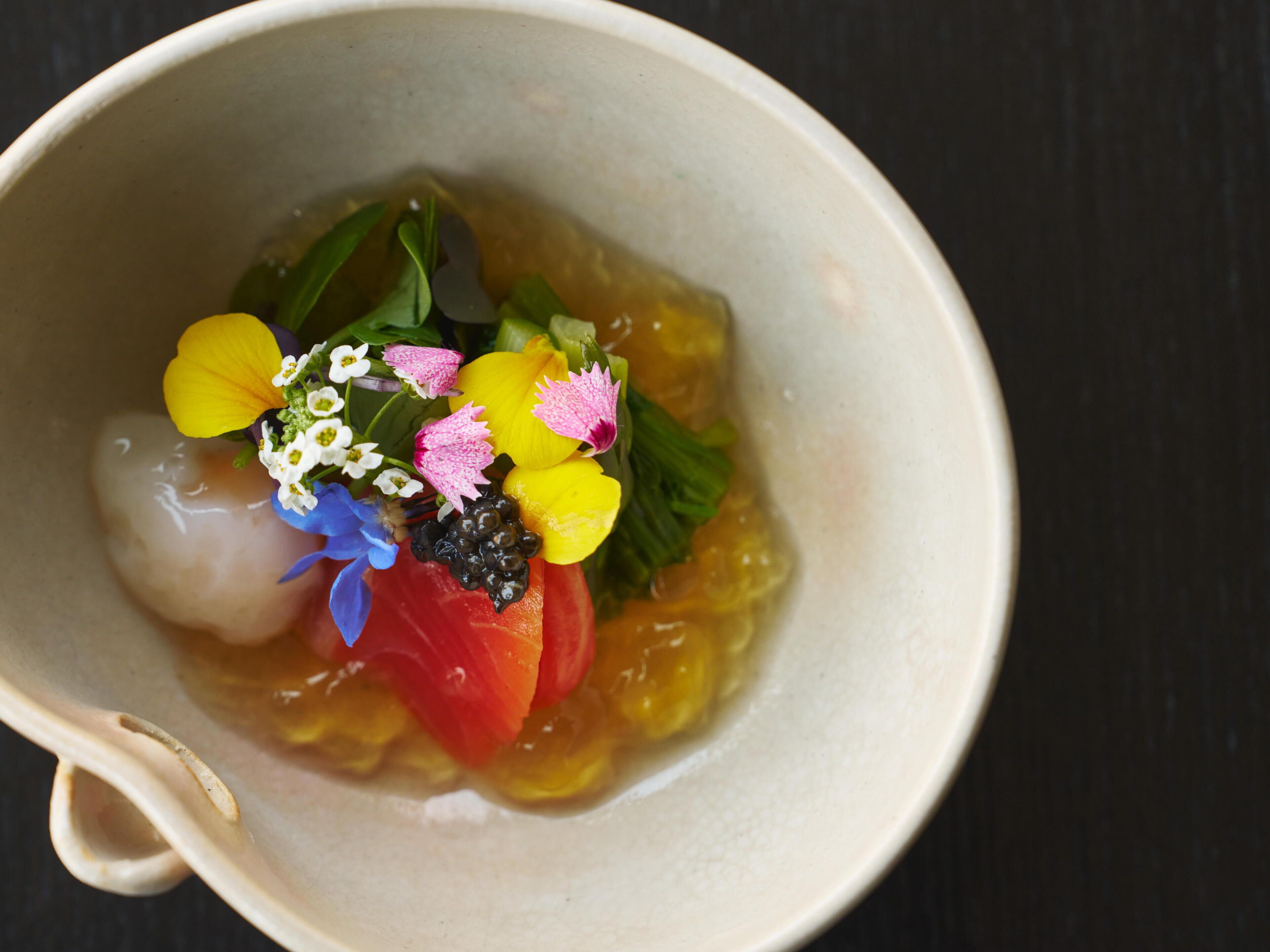Eine Tasse mit Blumen und einer Scheibe Tomate.