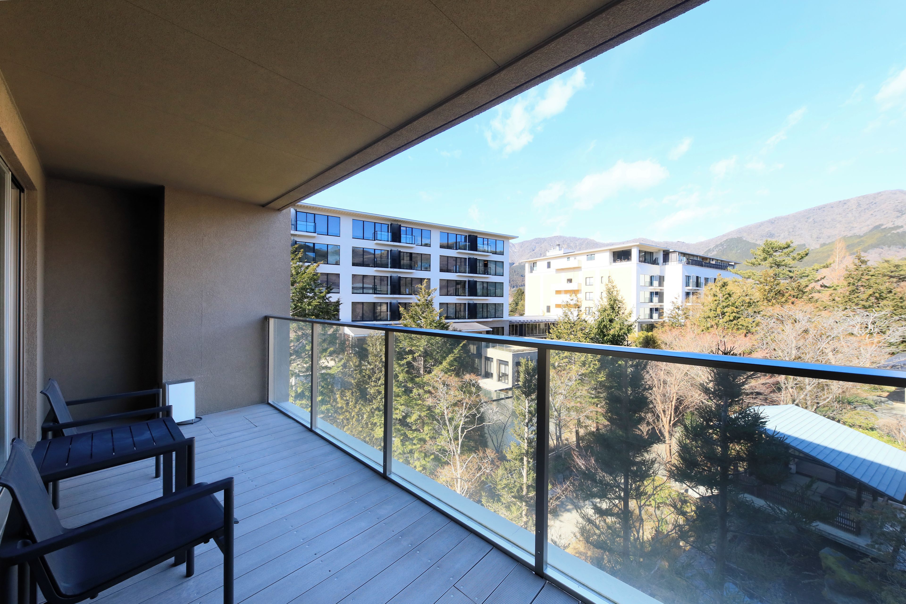 A balcony with a view of modern buildings and trees.