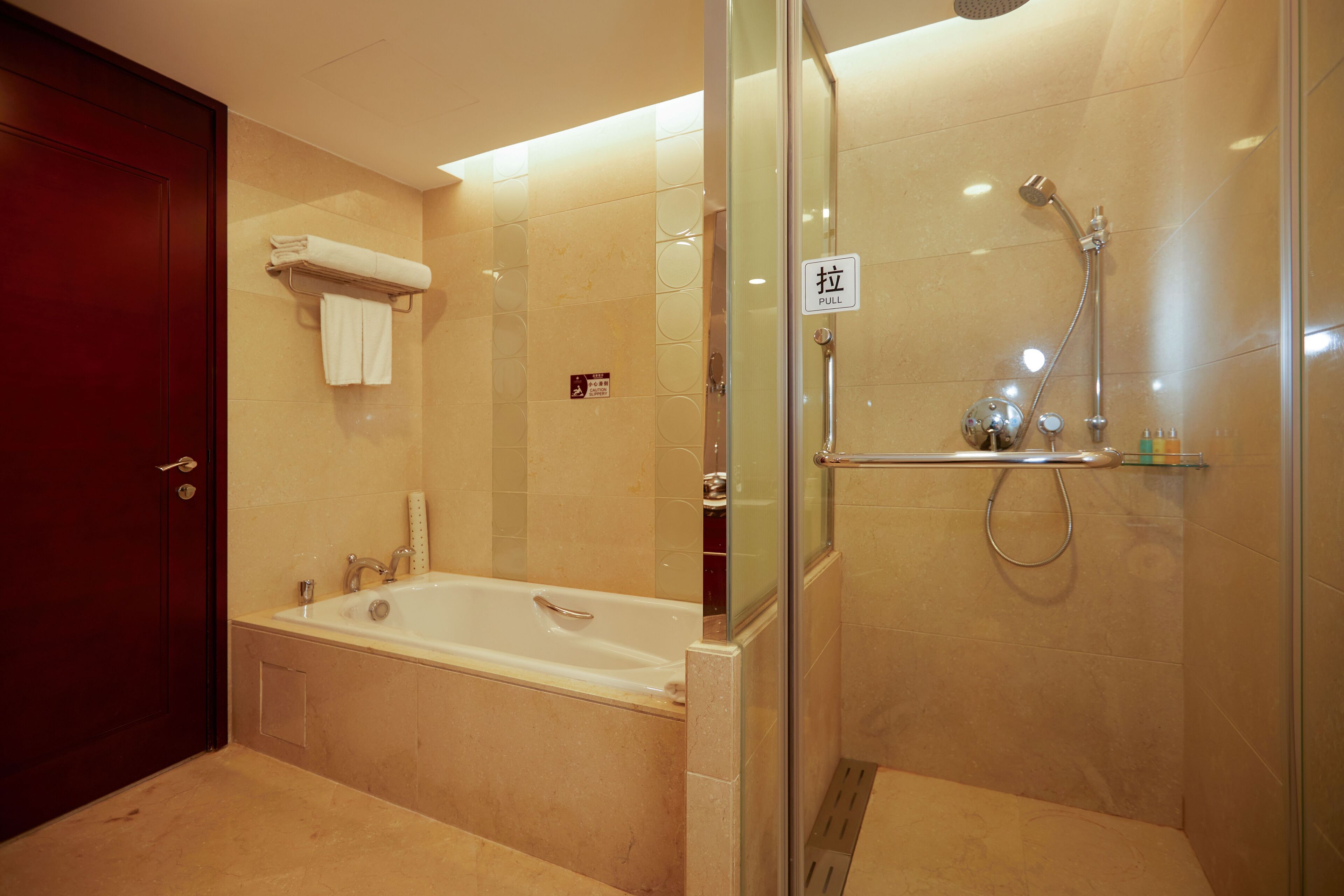 Ein modernes Badezimmer mit Badewanne, Dusche und einer Glastrennwand.