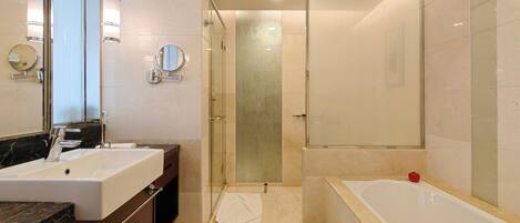 Un baño moderno con un lavamanos grande, una bañera y una ducha a ras de suelo.