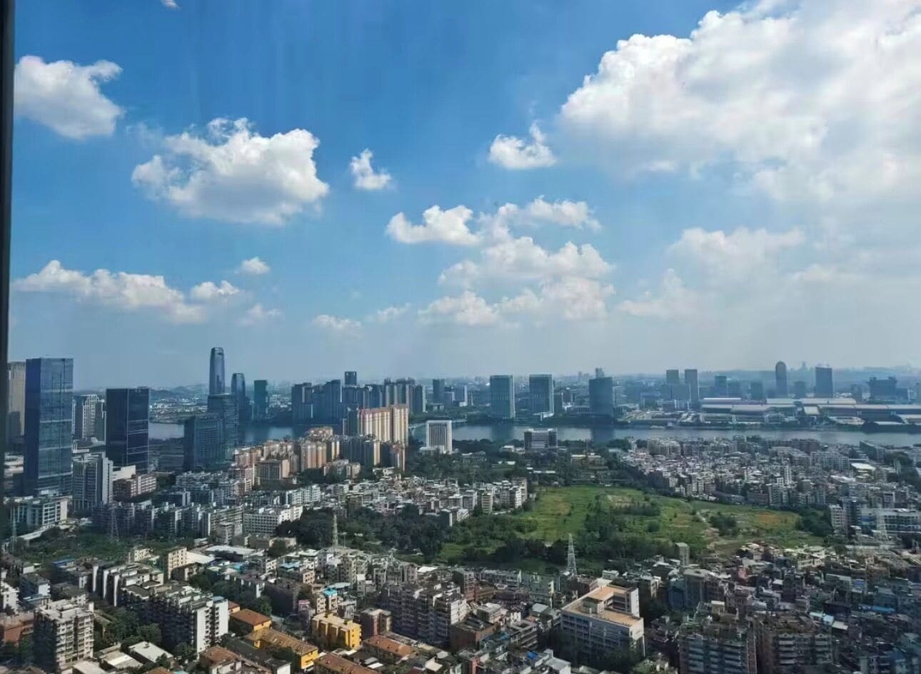 A cityscape with high-rise buildings, a river, and a park area.