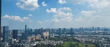 A cityscape with high-rise buildings, a river, and a park area.