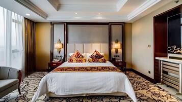 A hotel room with a large bed, two bedside tables with lamps, a chair, a desk, and a large mirror.