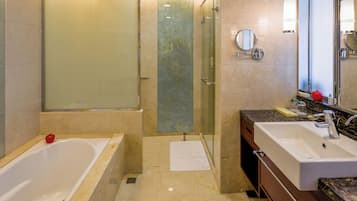 A modern bathroom with a glass-enclosed shower, a bathtub, a vanity with a mirror, and a sink.