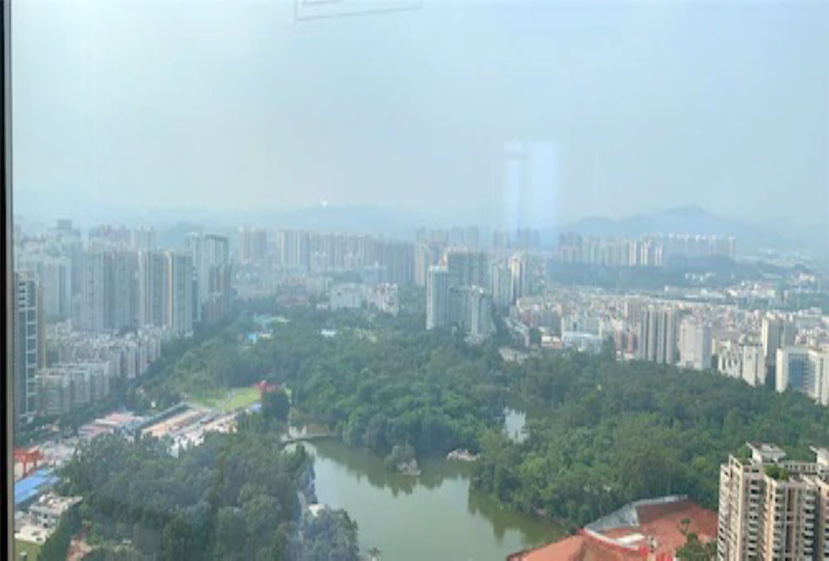 Un edificio alto con vistas a un río y vegetación circundante.