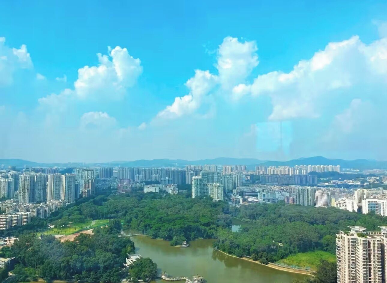 A cityscape with high-rise buildings, a river, and a bridge.