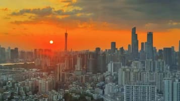 A cityscape at sunset with high-rise buildings and a prominent tower.