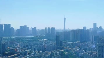 A cityscape with high-rise buildings, a prominent tower, and a river.
