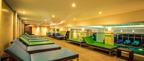 Un espace spa comprenant plusieurs tables de massage et une piscine.