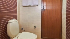 A small bathroom with a toilet, a sink, and a shower. - KTDC Nandanam Guruvayoor (Chavakkad)