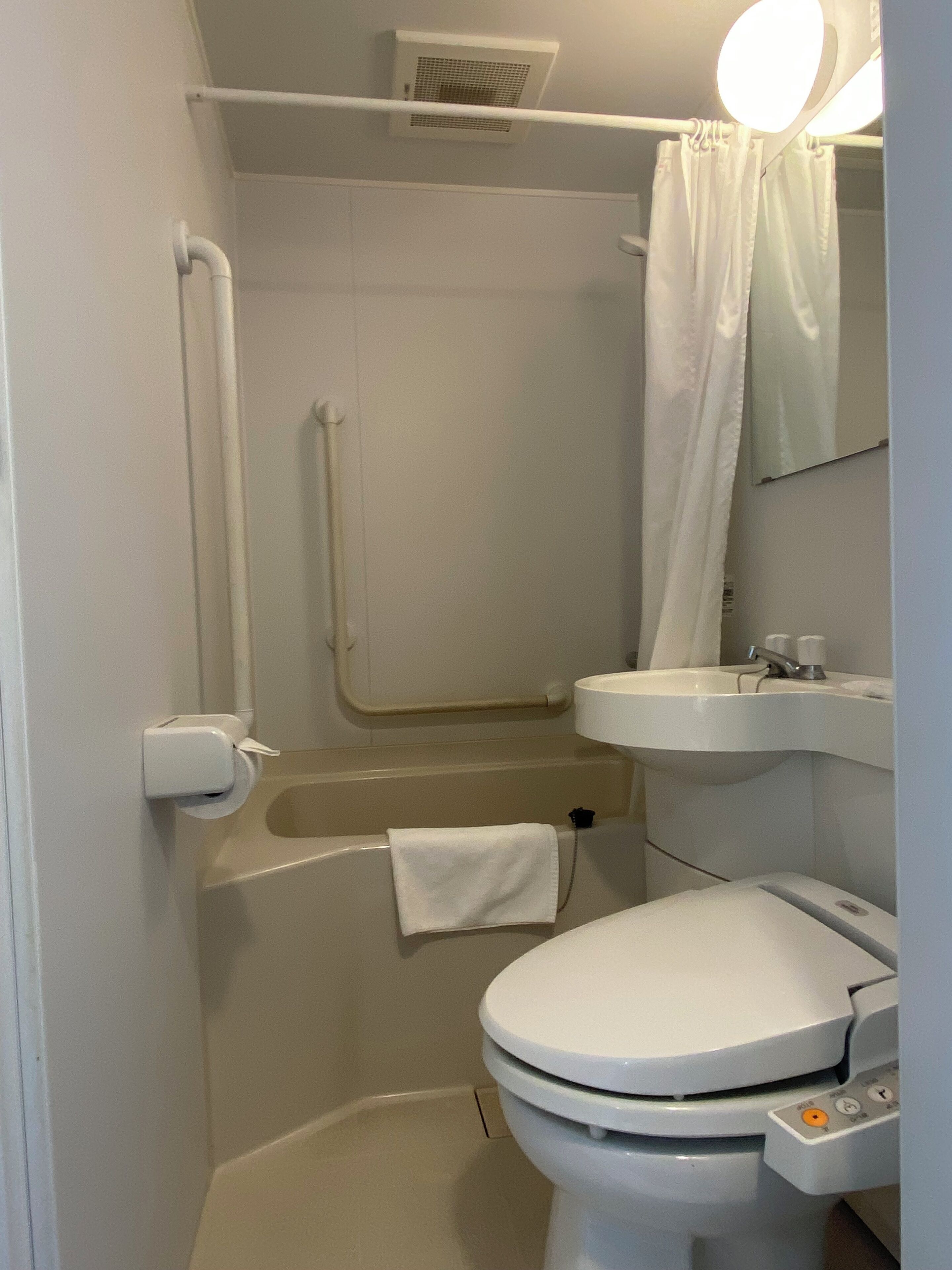 Une petite salle de bain moderne équipée de toilettes, d’un lavabo et d’une douche.