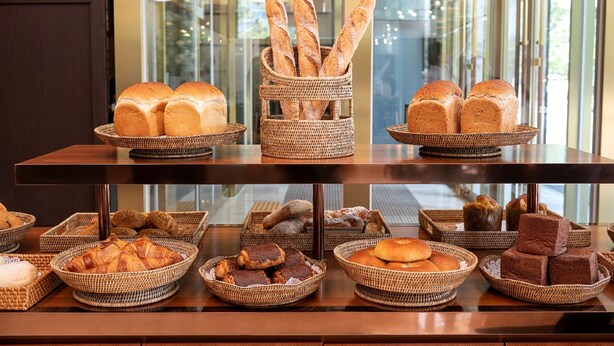 A buffet table with various breads and pastries displayed in wicker baskets. - Stanford Hotel Seoul (Seoul)