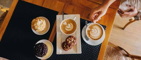 A table with a variety of pastries and coffee.