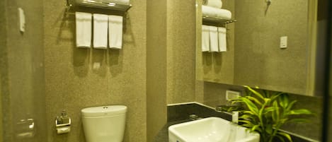 A bathroom with a toilet, sink, and towel rack.